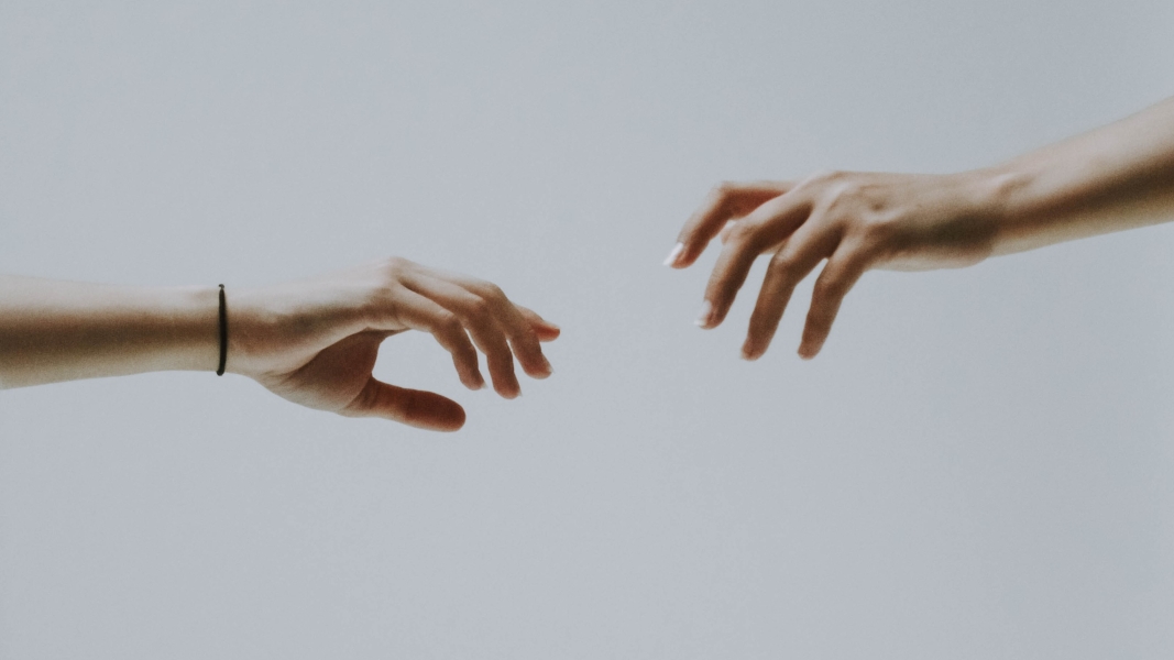 Two hands about to hold (Bild: fotografierende auf Unsplash)